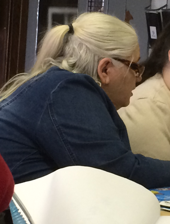 Diane is seated next to someone assisting them.