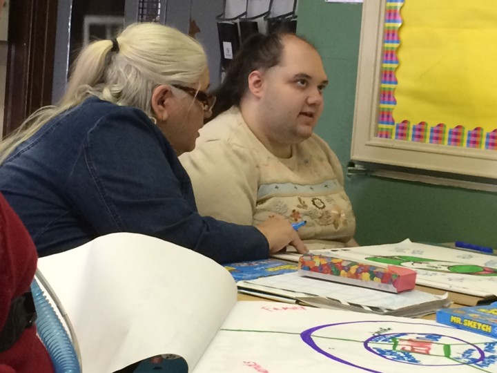 Diane is working with someone using colorful markers and lots of paper.
