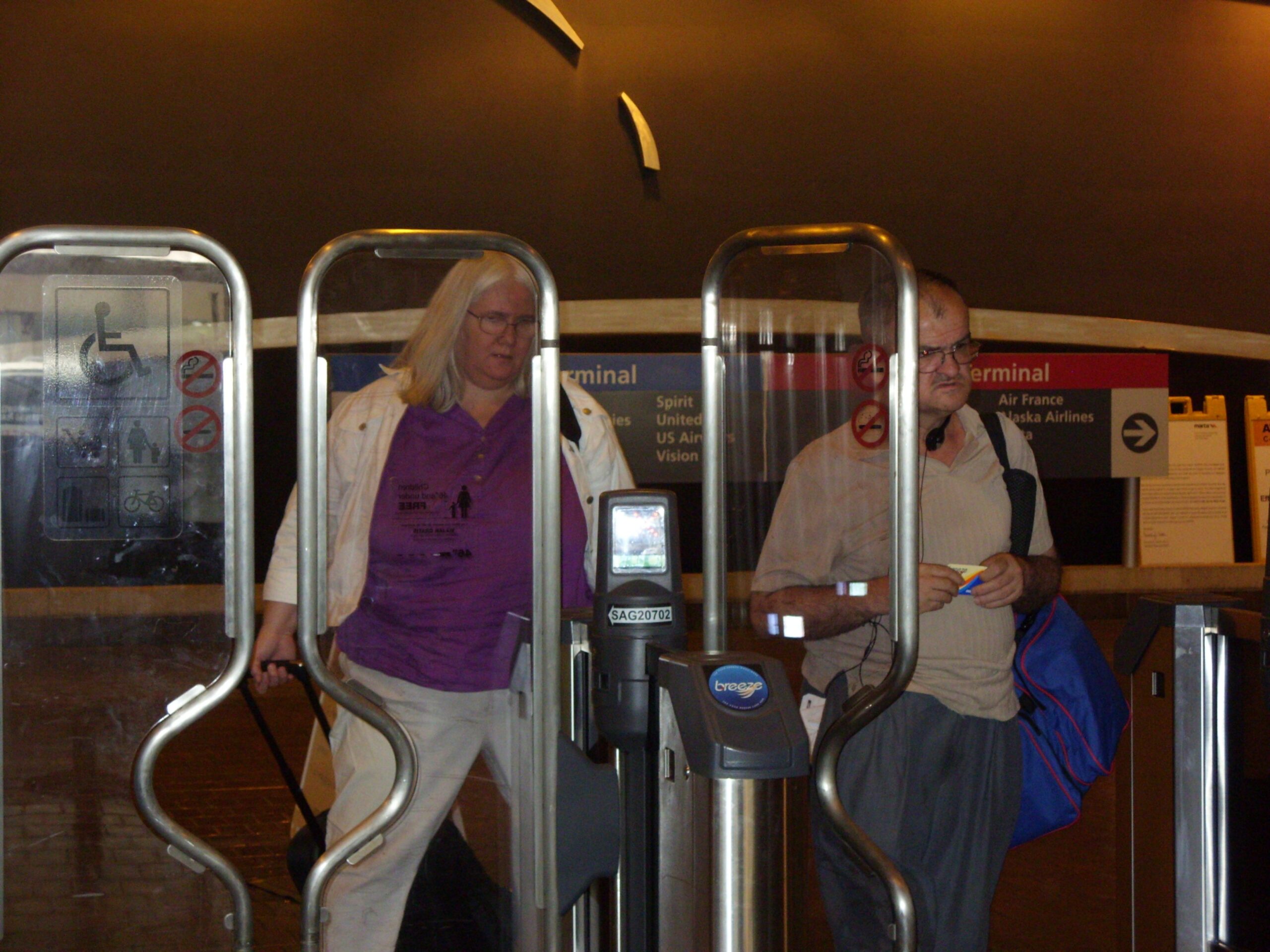 Diane and George are walking through the airport with their baggage.