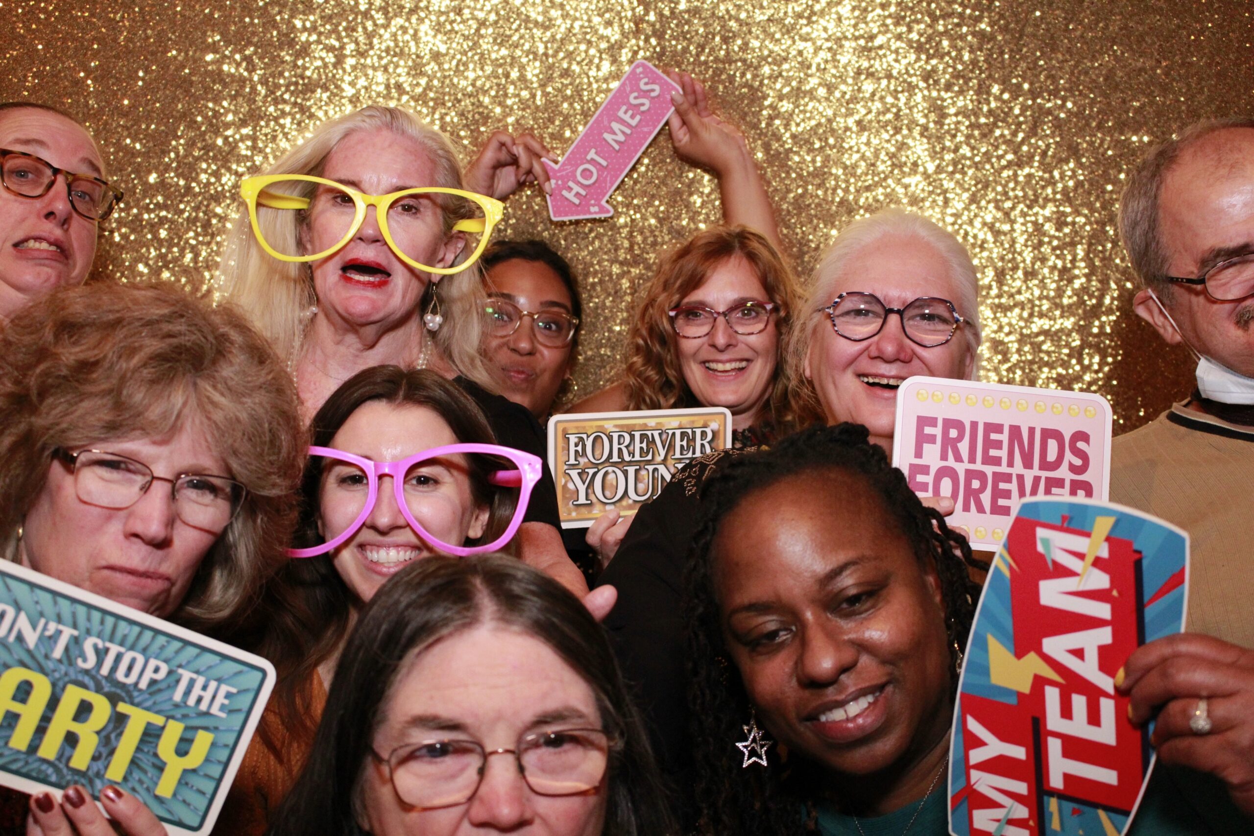 The Networks’ crew posing for a silly photo: Jess, Rosa, Nikita, Lexi, Tracy, Doris, Diane, Shauna, Michelle, George. Several holding silly signs like “forever young”, “don’t stop the party” and “friends forever”