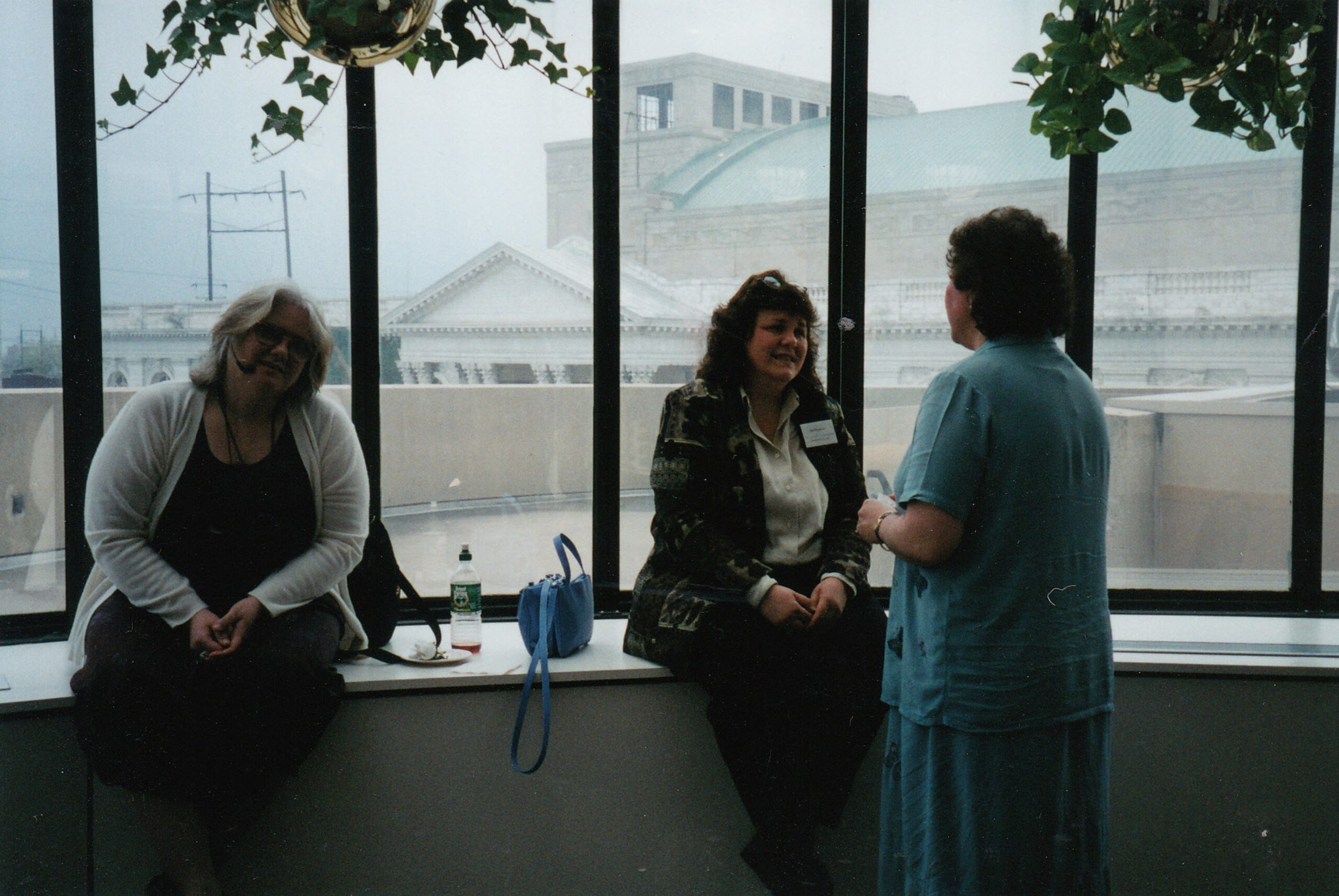 Diane and Pat seated on a window ledge at a conference venue.
