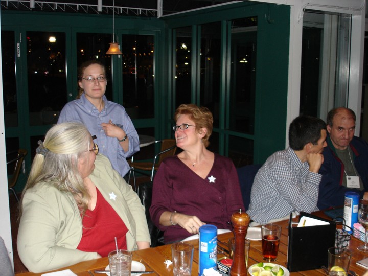 Rosa, Diane, and a few others are gathered at a table talking.